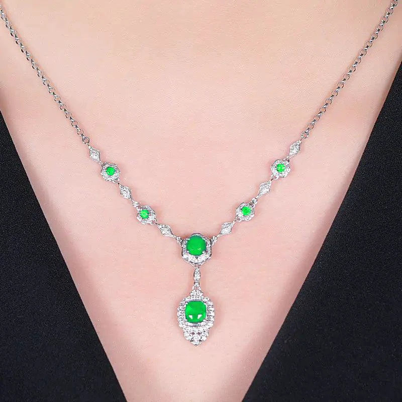 Mandotos Emerald Elegance white gold necklace with a central emerald gemstone and delicate chain design.