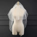 Ethereal double-tiered veil by MANDOTOS featuring delicate lace and airy tulle for a soft, romantic bridal look.