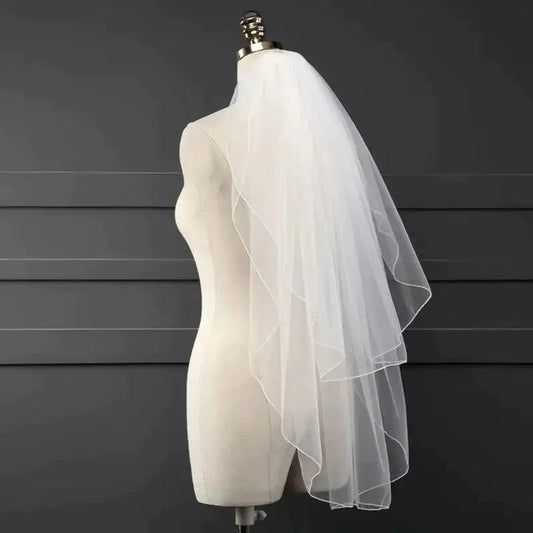 Ethereal double-tiered wedding veil by MANDOTOS featuring delicate lace and airy tulle layers for a romantic bridal look.