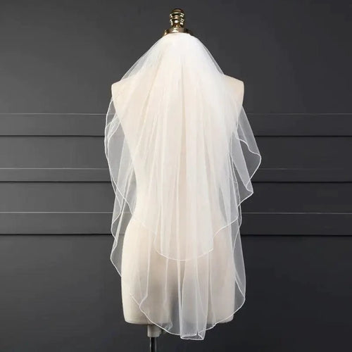 Ethereal double-tiered veil by MANDOTOS featuring delicate lace and soft tulle layers for a graceful bridal look.