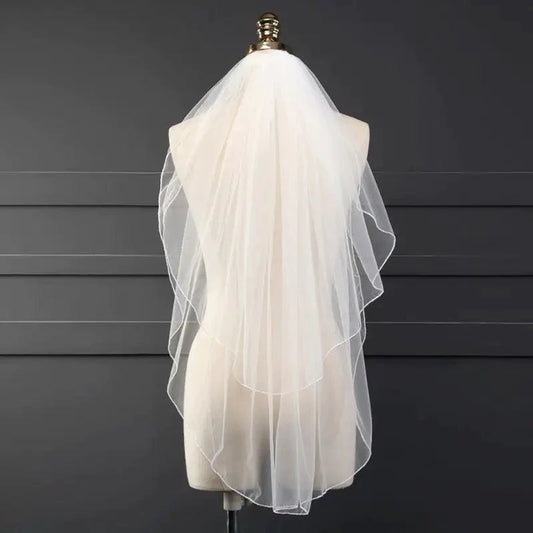 Ethereal double-tiered veil by MANDOTOS featuring delicate lace and soft tulle layers for a graceful bridal look.
