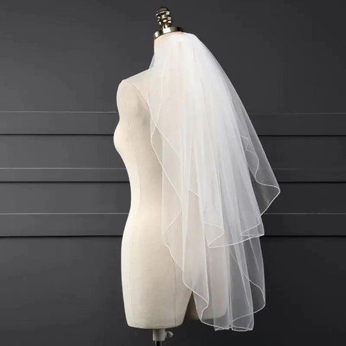 Ethereal double-tiered wedding veil by MANDOTOS, featuring delicate lace and sheer tulle layers for a romantic bridal look.