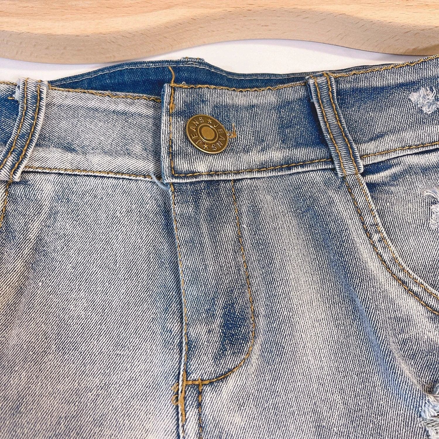 Light-colored high waist raw hem jeans by MANDOTOS, European chic style, showcasing distressed raw edges and classic denim fit.