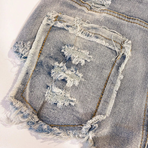 Light-colored high waist raw hem jeans by MANDOTOS featuring a European chic style and classic denim look.