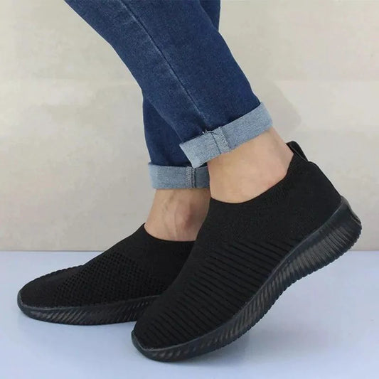 Mandotos flat knitted shoes in beige with white soles, showcasing a close-up view of the comfortable, stylish footwear.