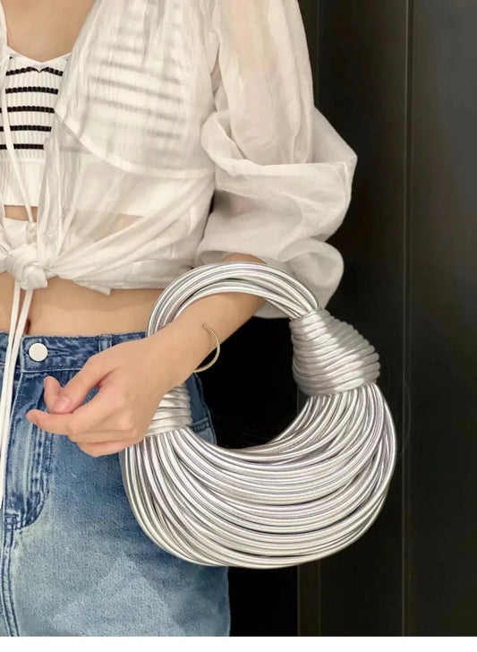 Mandotos gold luxury designer handbag for women with handwoven noodle design, rope knot details, and silver evening clutch style.