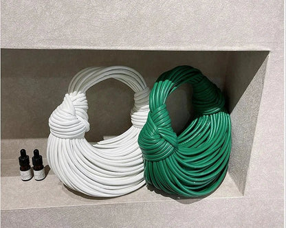 Mandotos gold luxury women's handbag featuring handwoven noodle design, rope knots, hobo style, and silver evening clutch appearance.
