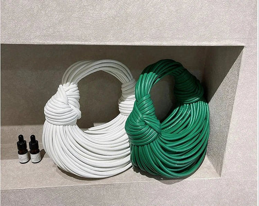 Mandotos gold luxury women's handbag featuring handwoven noodle design, rope knots, hobo style, and silver evening clutch appearance.