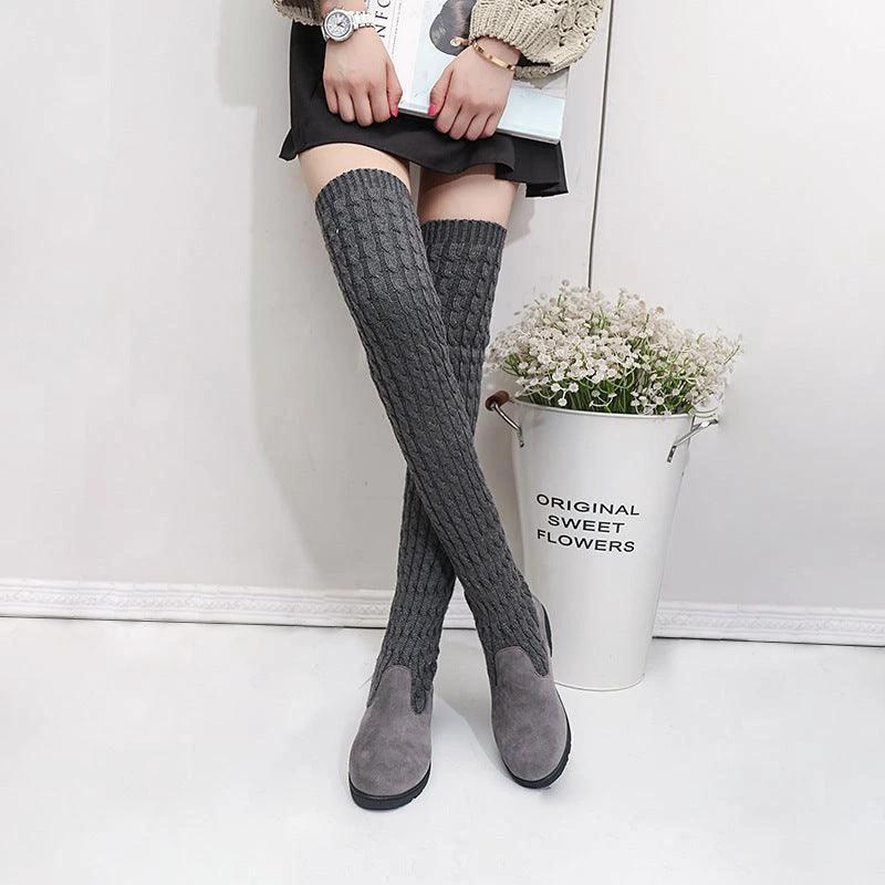 High flat over-the-knee stretch Martin boots by MANDOTOS, featuring sleek black design and knee-high length.