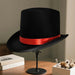 Elegant black top hat for adults costume, ideal for magicians and formal wear, featuring a classic design by MANDOTOS INTERNATIONAL.