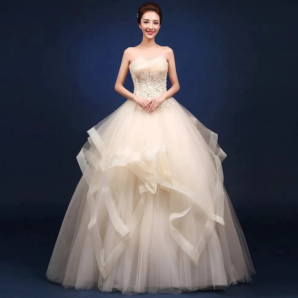 Elegant one-shoulder bridal gown by MANDOTOS INTERNATIONAL with flowing fabric and intricate lace detailing.