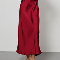 European American style satin midi skirt by MANDOTOS INTERNATIONAL, shown in a stylish, flowing design on a model.