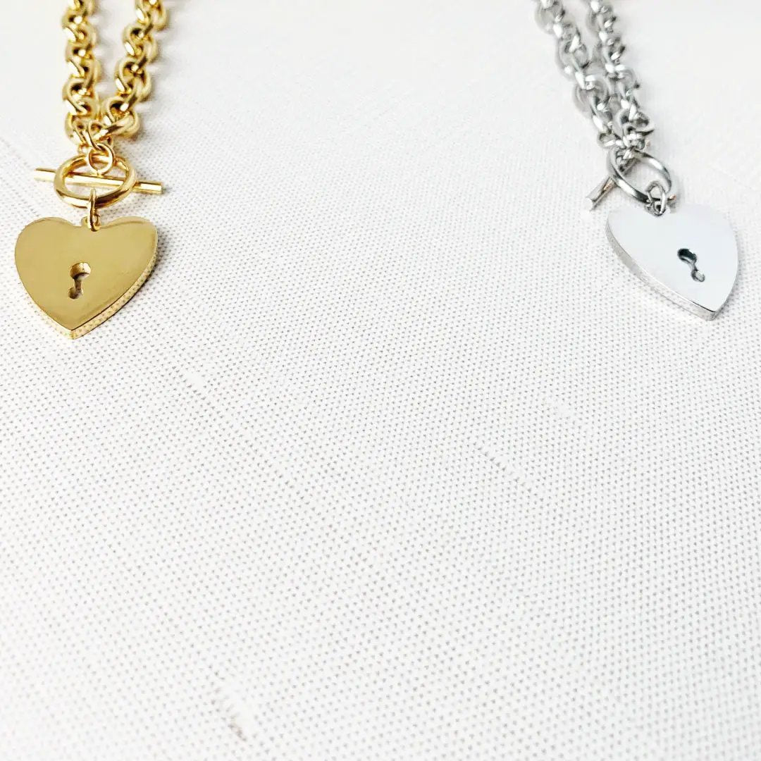 Heart-shaped key toggle necklace by MANDOTOS INTERNATIONAL featuring a silver chain and a detailed heart-shaped key pendant.