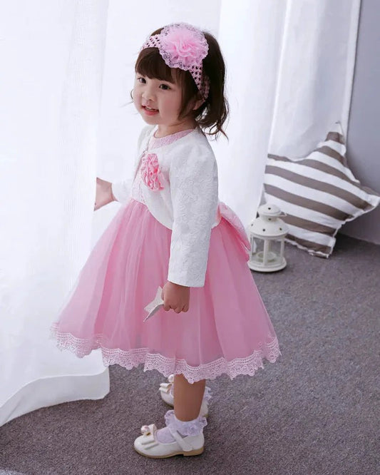 Pink Little Princess gown by MANDOTOS INTERNATIONAL with ruffled sleeves and satin bow, perfect for special occasions.