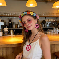 Mandotos International PESENAR 60s Hippie costume accessory set with flower headband, pink sunglasses, and peace sign jewelry.