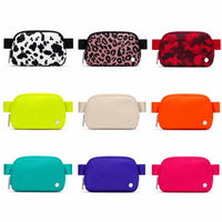 Mandotos International lightweight women’s waist bag for running and travel, shown in black with adjustable strap and zippered pocket.