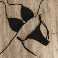 Solid micro bikini set with tie-side G-string design, Brazilian style, featuring the MANDOTOS INTERNATIONAL brand logo.