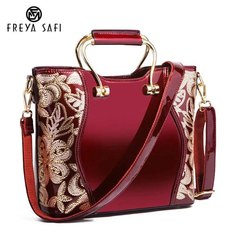 Mandotos elegant floral leather tote in burgundy with embroidered details and a detachable crossbody strap.