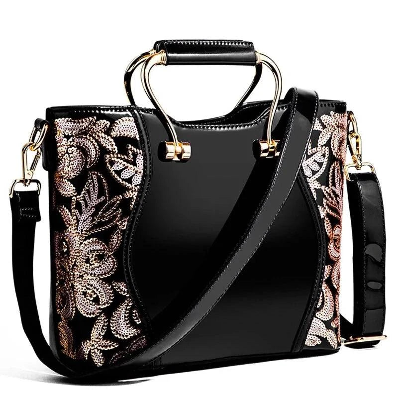 Mandotos elegant floral leather tote in burgundy with embroidered design and crossbody strap for versatile style.