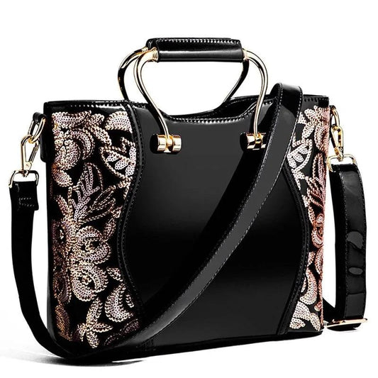 Mandotos elegant floral leather tote in burgundy with embroidered design and crossbody strap for versatile style.