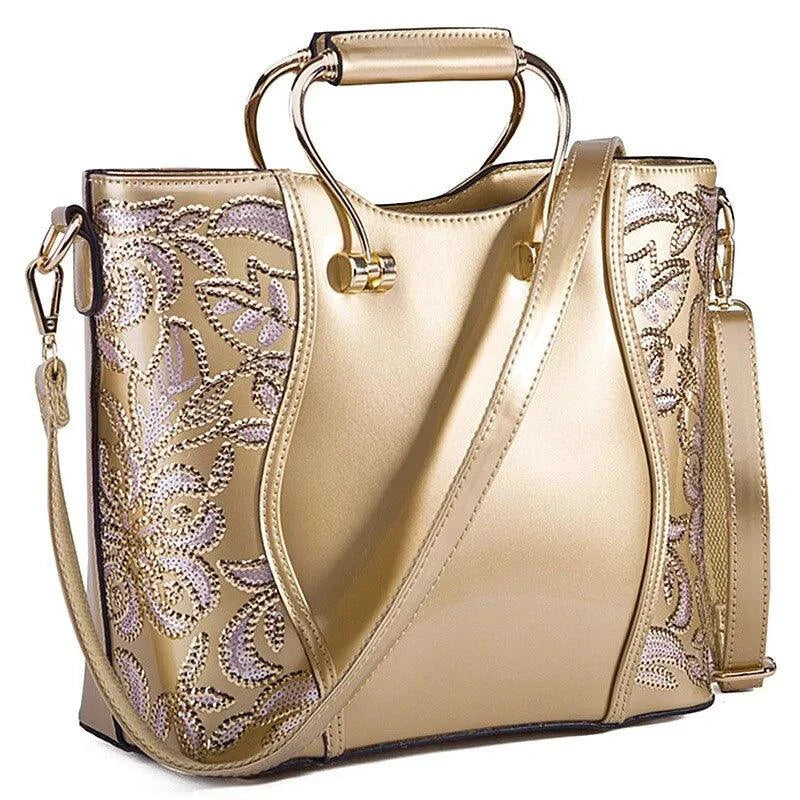 Mandotos elegant floral leather tote bag in burgundy with embroidered design and a crossbody strap for versatile style.