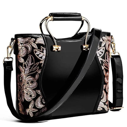 Mandotos elegant floral leather tote bag in burgundy with embroidered details and a removable crossbody strap.