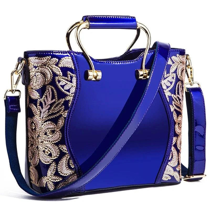 Mandotos elegant floral burgundy leather tote bag with embroidered design and crossbody strap detail.