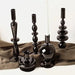 Mandotos Elegant Rue black glass candlestick holder on a table, stylish centerpiece with a sleek, modern design.