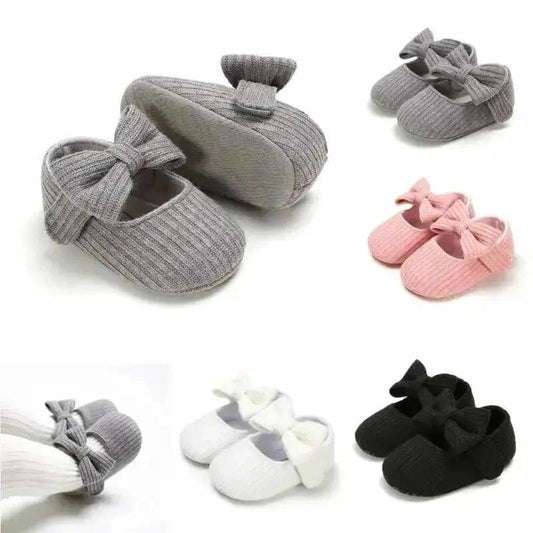 Soft newborn shoes by MANDOTOS with pink and white design, featuring comfortable fabric and tiny bow details.