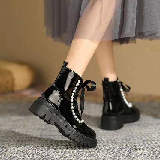 Black patent leather ankle boots by MANDOTOS with sleek design and pointed toe, stylish footwear for versatile outfits.