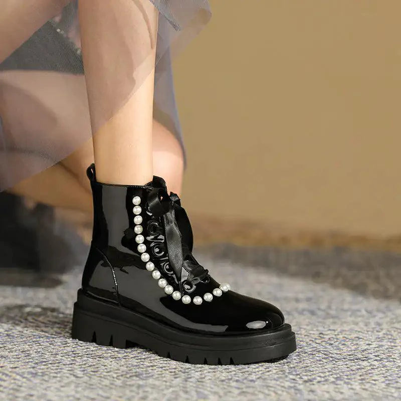 Black patent leather ankle boots by MANDOTOS with a sleek, shiny finish and stylish ankle-height design.