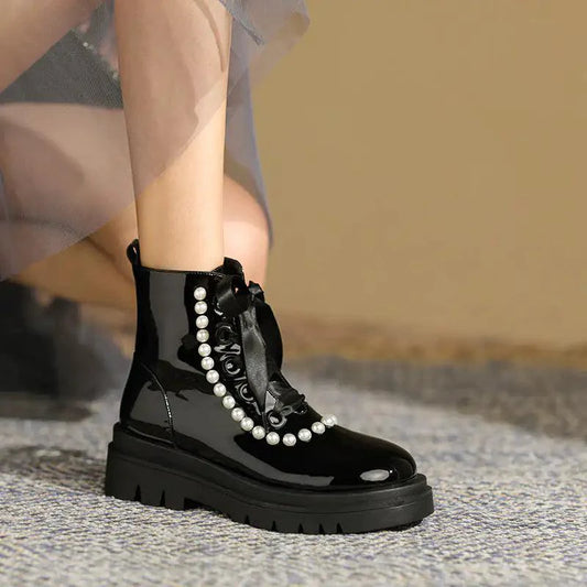 Black patent leather ankle boots by MANDOTOS with a sleek, shiny finish and stylish ankle-height design.