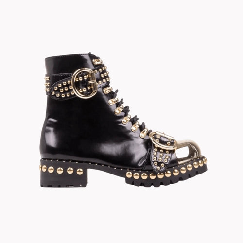 Mandotos rugged studded buckle boots featuring chunky heel, leather straps, and metal buckle for a bold, edgy look.