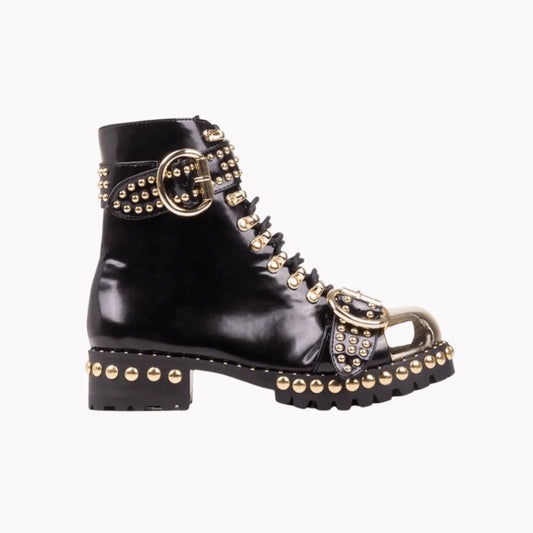 Mandotos rugged studded buckle boots featuring chunky heel, leather straps, and metal buckle for a bold, edgy look.