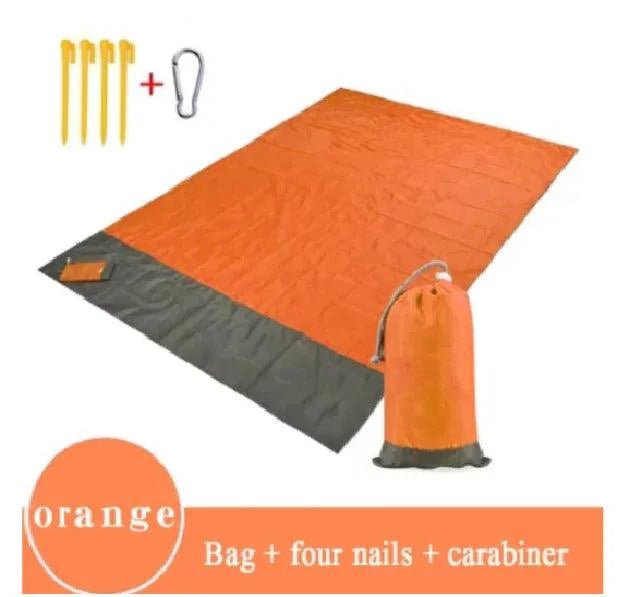 Mandotos sandproof portable beach mat spread out on sandy shore, lightweight and easy to carry for beach outings.