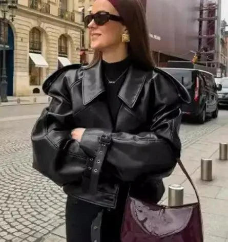 Mandotos sleek matte leather coat displayed on a hanger, showcasing its smooth finish and tailored design.