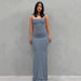 Mandotos sleek satin backless gown featuring a smooth, shiny fabric and elegant design, perfect for formal events.