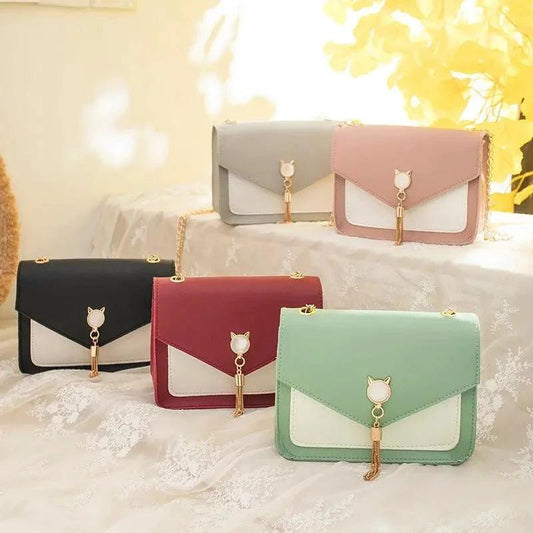Mandotos small women's crossbody bag with cat lock chain detail, messenger style, black faux leather, stylish and compact.