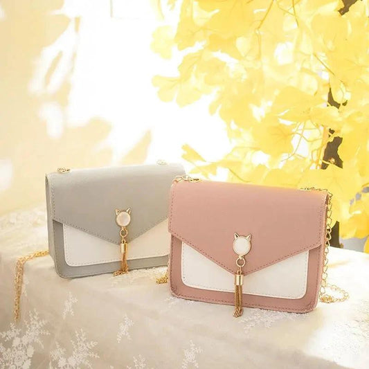Small women's crossbody bag by MANDOTOS featuring a cat lock chain design and compact messenger style.