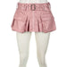 Mandotos Spice faux leather pleated mini skirt hanging on a hanger, showcasing its textured fabric and stylish design.