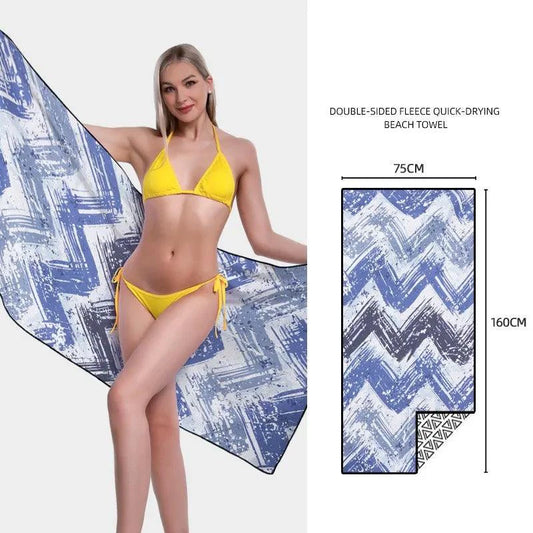 Mandotos SwiftDry patterned beach towel with colorful geometric design laid out on sandy beach.