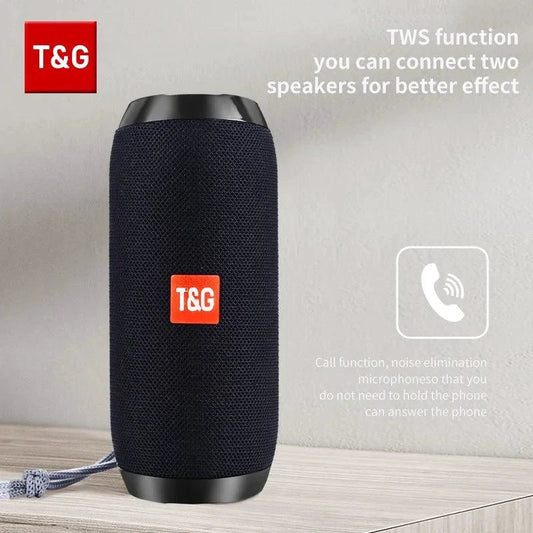 Mandotos TG117 Bluetooth portable waterproof TWS outdoor speaker placed on a surface with a nature background.
