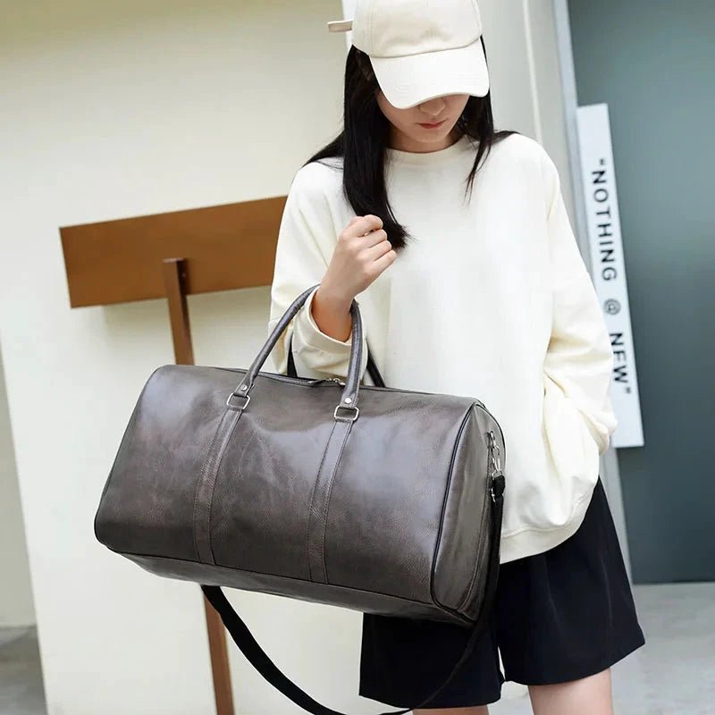 Mandotos men's travel bag in black PU leather with shoulder strap, large capacity tote and duffle style for women and men.