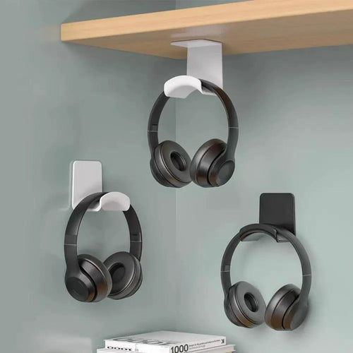 Universal headphone stand wall mount holder in adhesive plastic, supporting gaming earphones and headset under desk or on wall.
