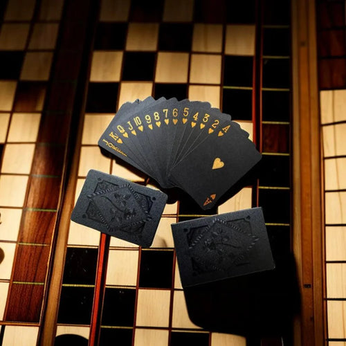 Black and gold waterproof playing cards for poker and magic tricks, part of a collectible card game set.