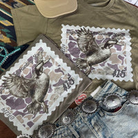 Olive green Duck Stamp graphic tee by Wild Junkie featuring a detailed duck stamp design on a casual graphic tee.